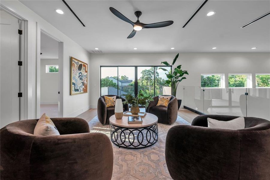 Living area with recessed lighting, healthy amount of natural light, wood finished floors, and a ceiling fan Living area with recessed lighting, healthy amount of natural light, wood finished floors, and a ceiling fan