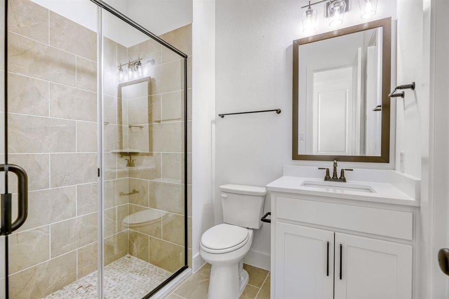 Bathroom featuring vanity, a stall shower, and light tile patterned floors