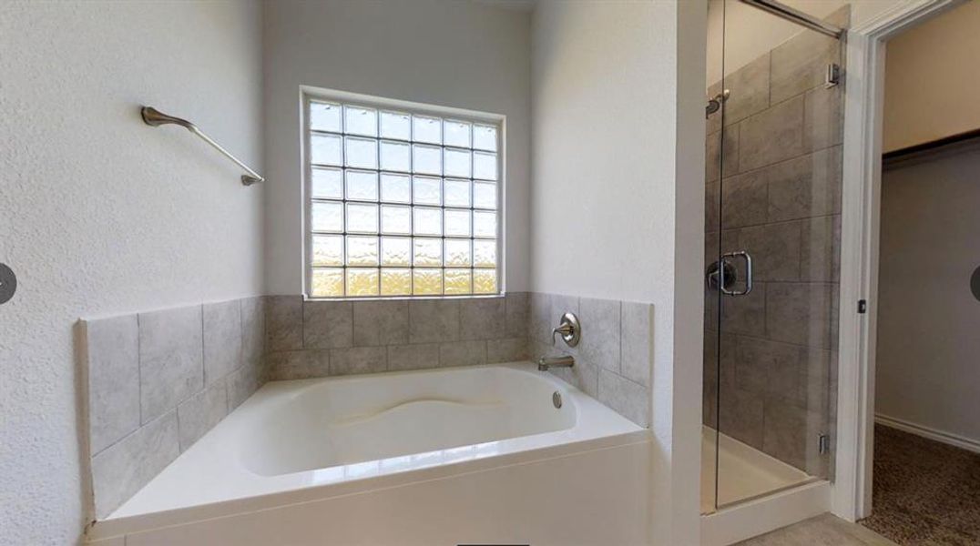 Bathroom featuring a stall shower and a garden tub