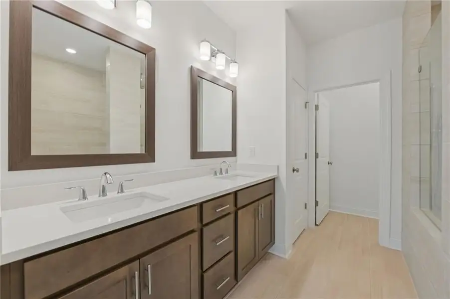Primary bathroom with separate undermount sinks, and framed mirrors - Home is under construction and estimated to be completed in June/July 2026 
Pictures represent a previously built home not the actual home