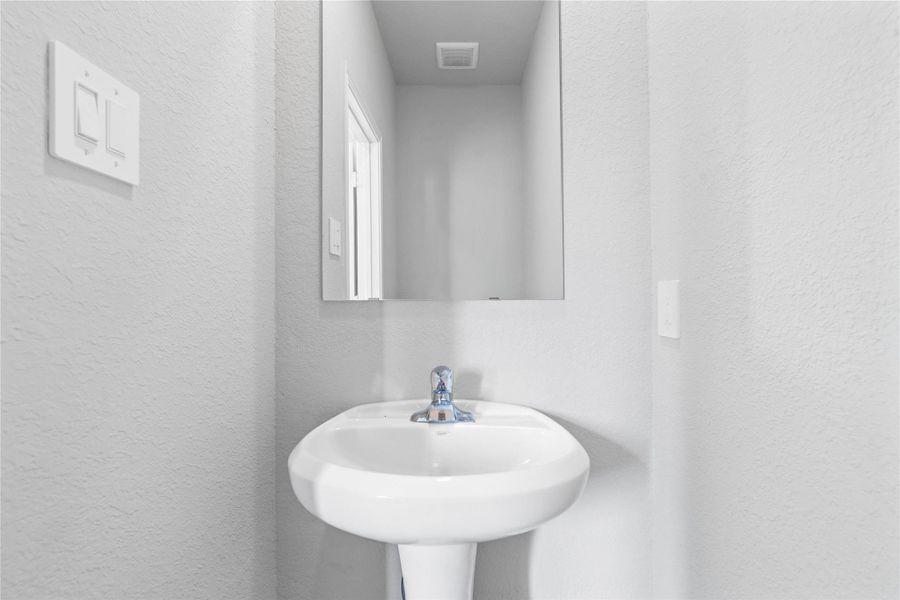 Strategically located on the main level, this half-bath allows guests to freshen up easily without having to navigate through the private areas of the home, such as the bedrooms or personal full bathrooms.