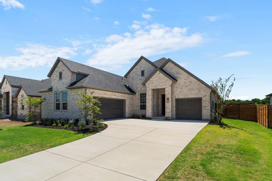 A graceful facade of light brick and dark roofing welcomes with an inviting double garage and lush landscaping.