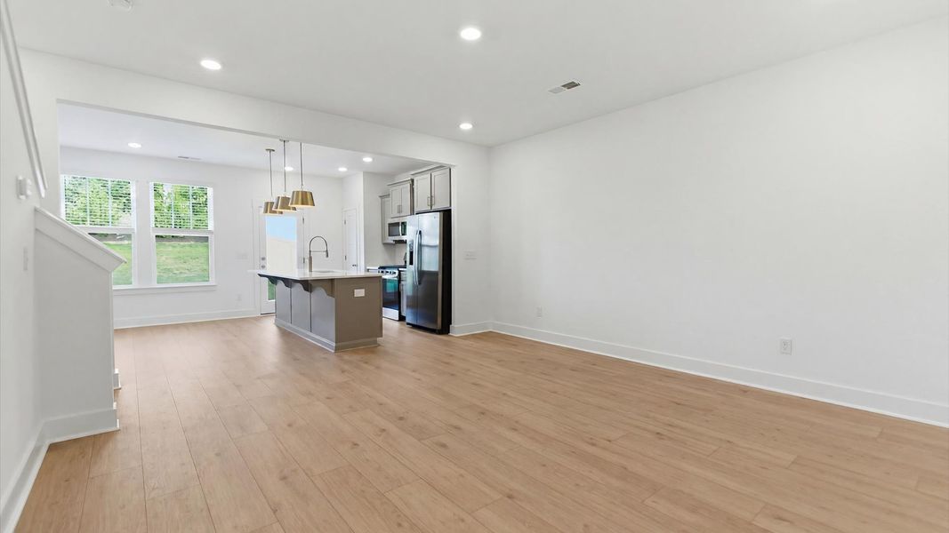 Spacious family room with rich hardwood flooring and elegant trim work in a reputable DRB Homes build