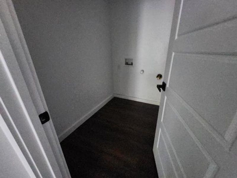 Washroom featuring dark wood-style floors and hookup for a washing machine Washroom featuring dark wood-style floors and hookup for a washing machine