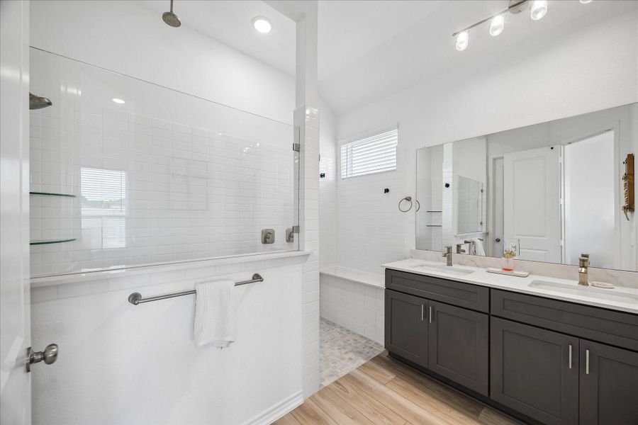 Spa-like bath featuring dual sinks, a walk-in shower, and modern finishes.