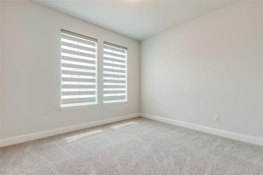 Carpeted empty room featuring baseboards