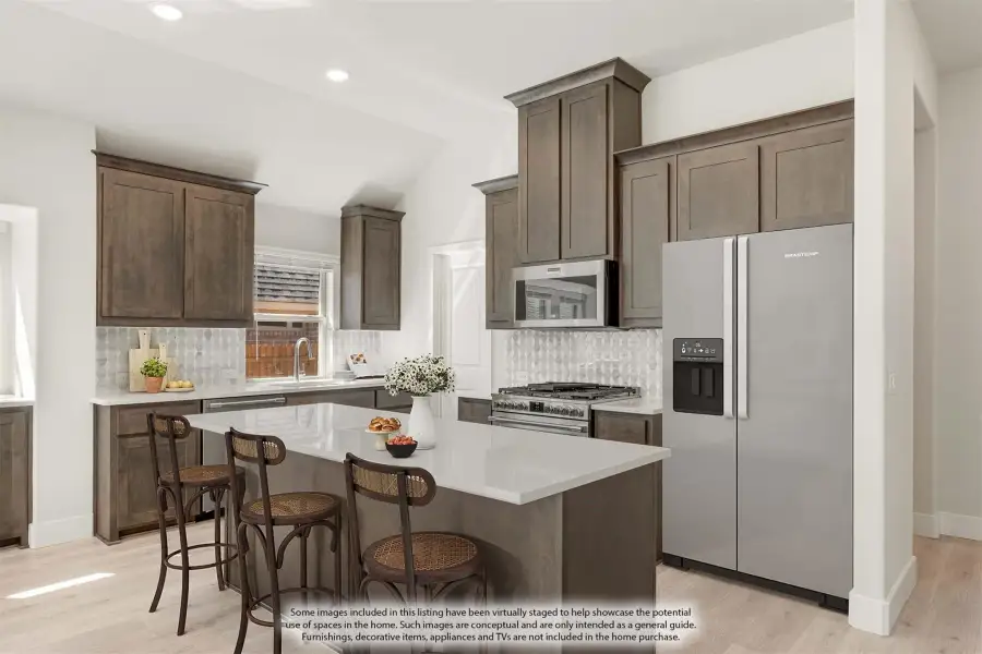 Kitchen with dark brown cabinets, center island with seating, stainless steel appliances, and patterned tile backsplash