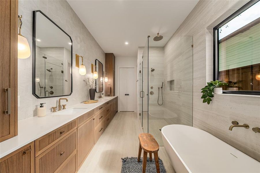 Bathroom featuring a shower stall, a freestanding bath, double vanity, tile walls, and recessed lighting Bathroom featuring a shower stall, a freestanding bath, double vanity, tile walls, and recessed lighting