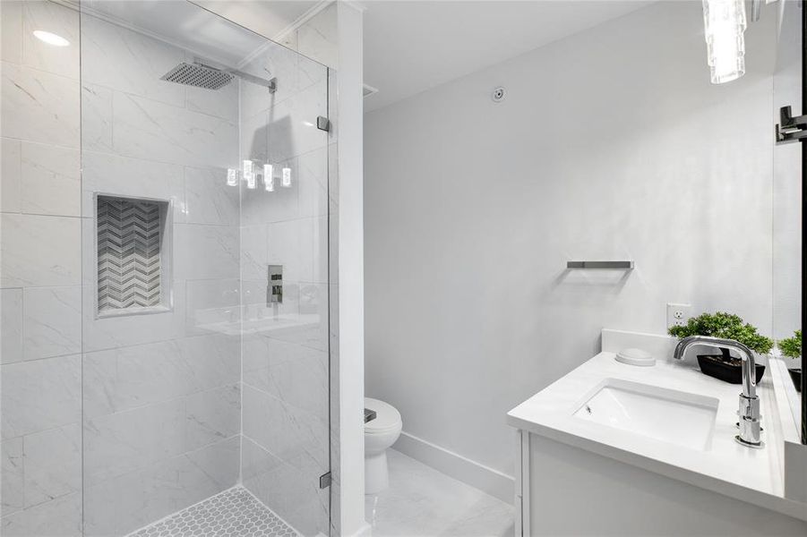 Bathroom featuring an enclosed shower, toilet, and vanity