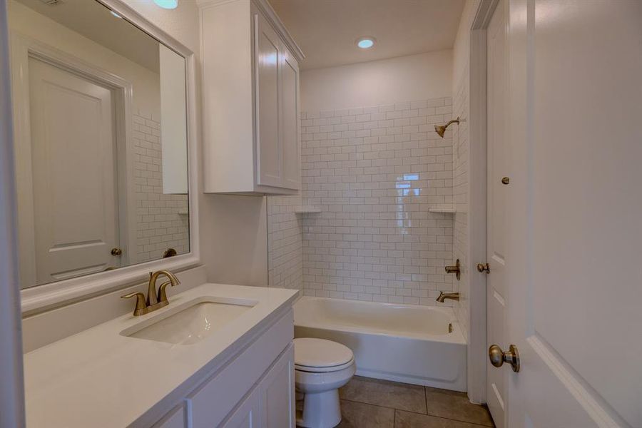 Full bathroom featuring toilet, tile patterned floors, vanity, shower / bath combination, and recessed lighting