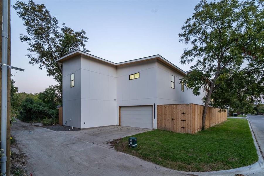 Property exterior at dusk with a garage and a yard