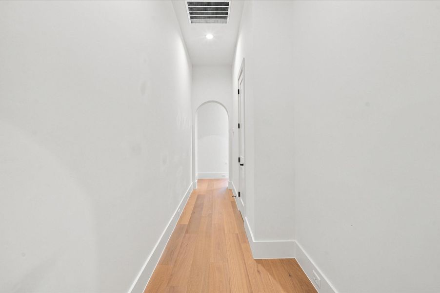 Arched doorway leads to kitchen and living area.