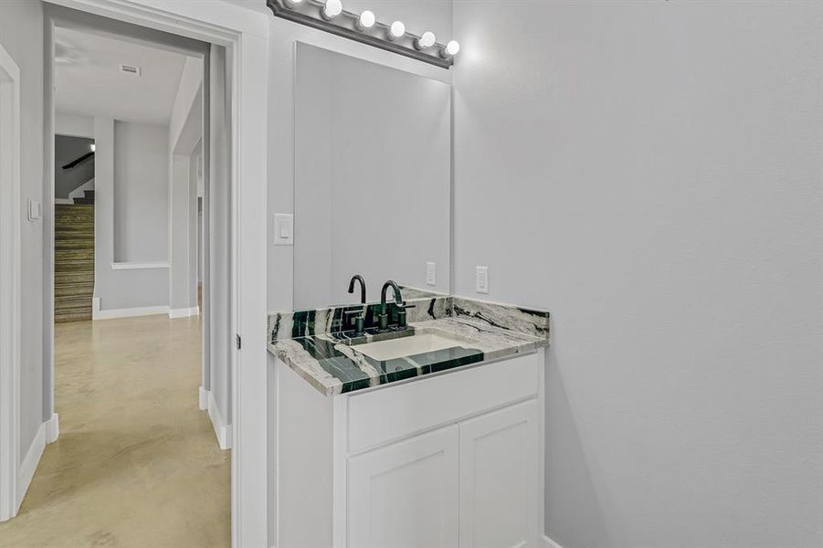 Bathroom with concrete floors, baseboards, and vanity
