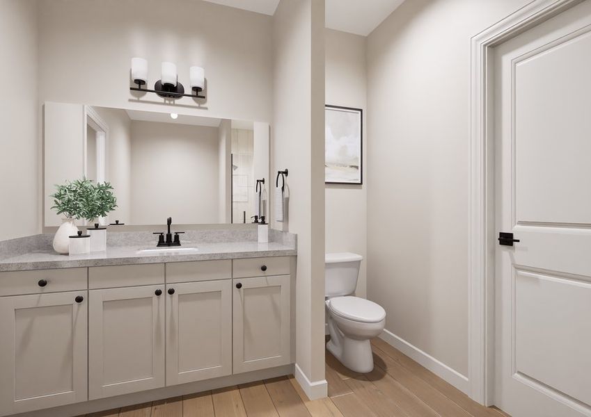 A modern bathroom featuring a white vanity, black faucets, and a large mirror. A black light fixture is above, and there's a toilet beside a closed door. A modern bathroom featuring a white vanity, black faucets, and a large mirror. A black light fixture is above, and there's a toilet beside a closed door.