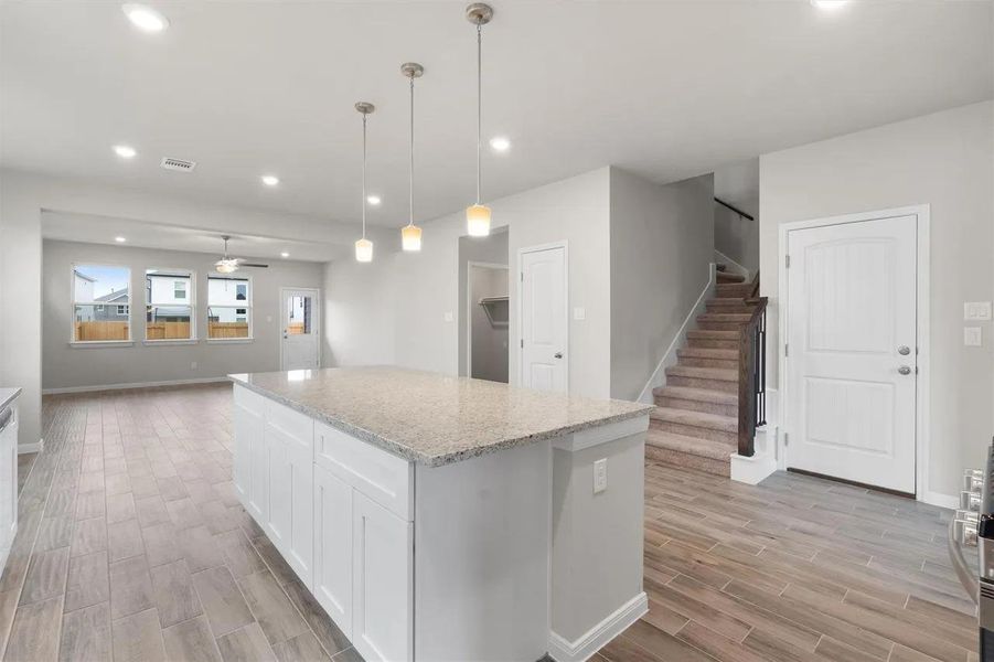 An open-concept living space with a spacious kitchen island and elegant pendant lighting.
