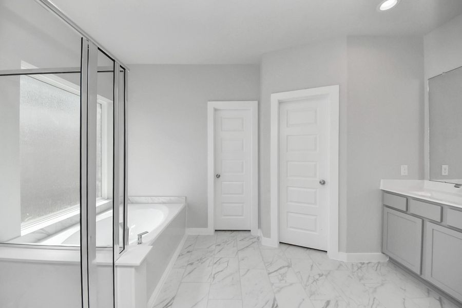 Escape to a spa-like oasis in this primary bathroom. Enjoy a walk-in shower with tile surround, a separate garden tub with custom detailing, and an elegant vanity featuring light countertops, modern hardware, and beautiful recessed lights. Experience luxury and relaxation in every detail. Escape to a spa-like oasis in this primary bathroom. Enjoy a walk-in shower with tile surround, a separate garden tub with custom detailing, and an elegant vanity featuring light countertops, modern hardware, and beautiful recessed lights. Experience luxury and relaxation in every detail.
