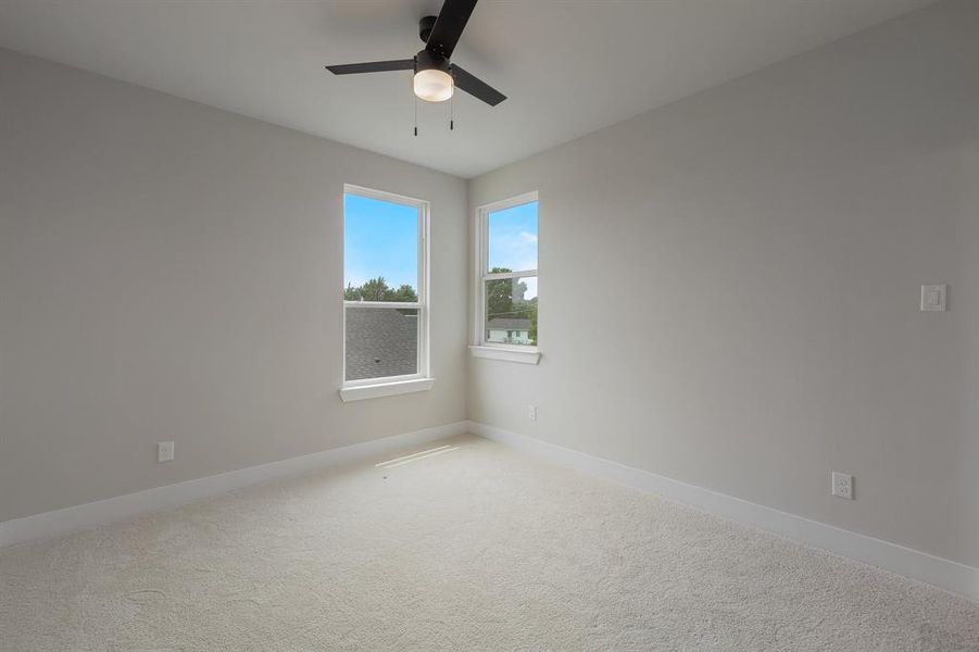 Spare room with ceiling fan, baseboards, and carpet floors