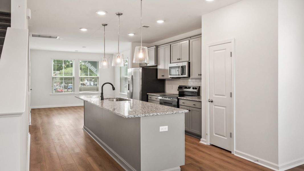 Kitchen in Hayden Floorplan with large island and lots of natural light at Clear Springs Townhomes