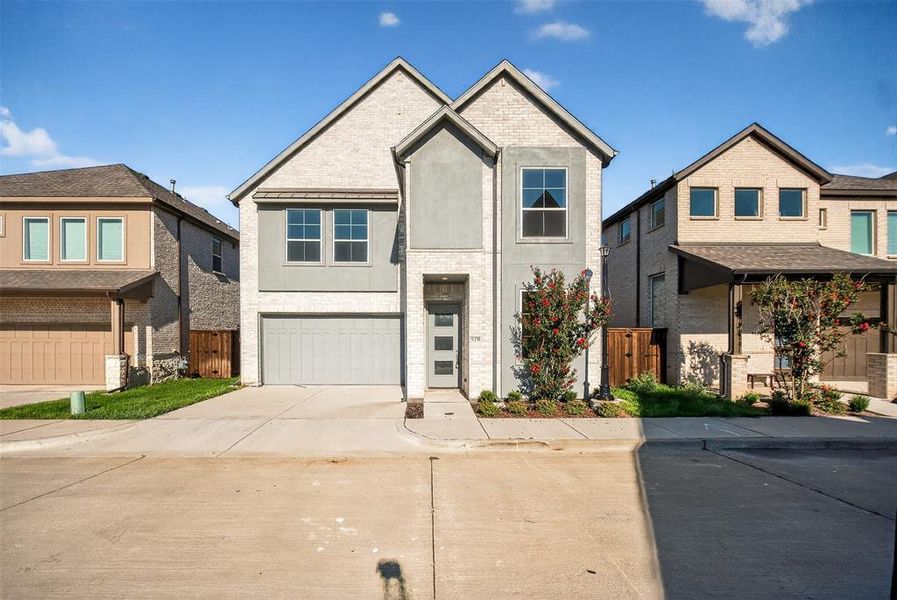 View of front of house featuring concrete driveway, brick siding, an attached garage, and stucco siding View of front of house featuring concrete driveway, brick siding, an attached garage, and stucco siding