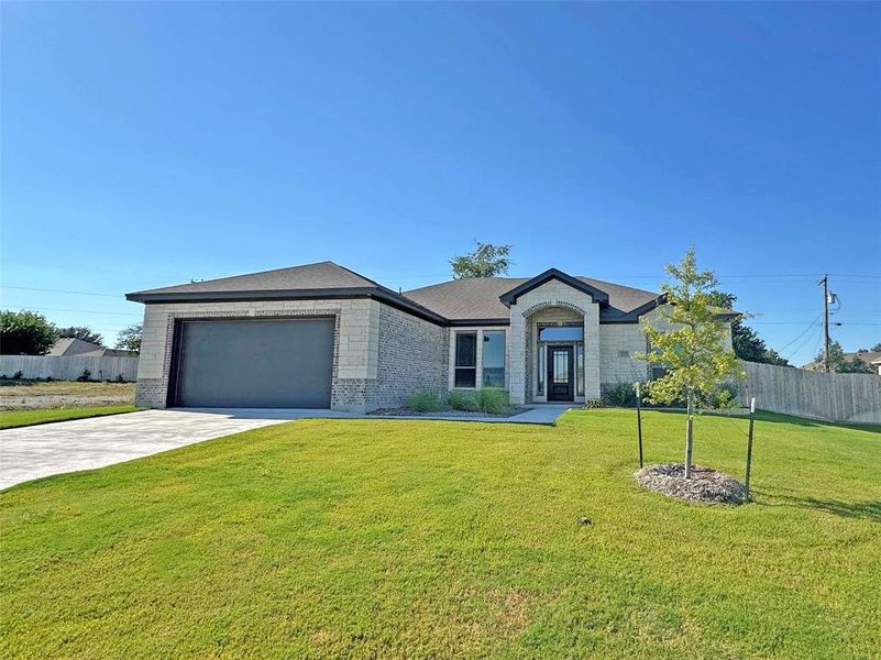 Ranch-style home featuring concrete driveway, brick siding, and an attached garage Ranch-style home featuring concrete driveway, brick siding, and an attached garage