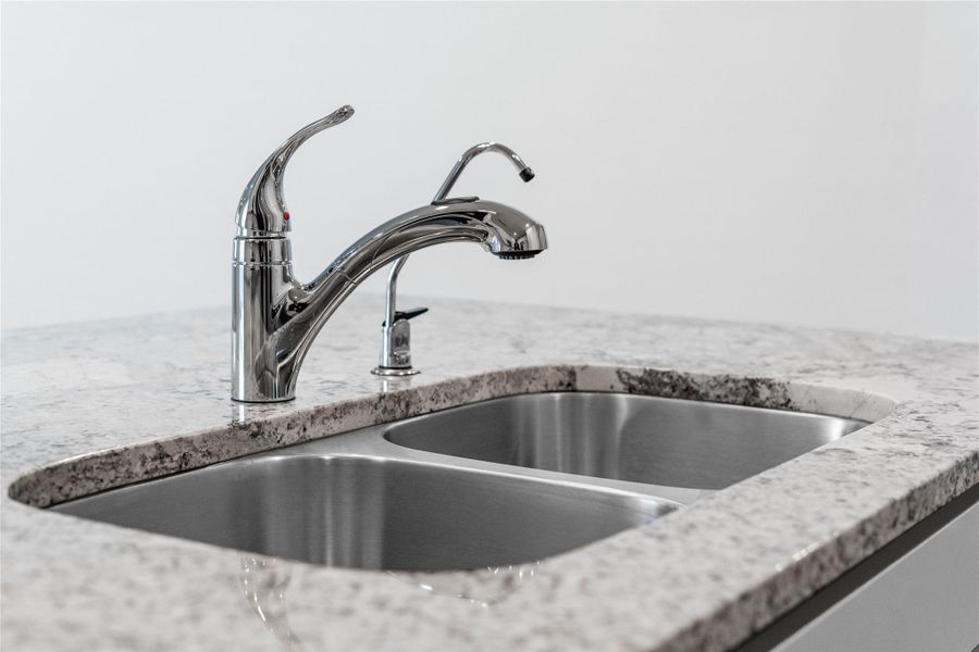 The kitchen features a stainless steel 50/50 undermount sink and a Moen Integra chrome kitchen faucet with DuPure water filtration system.