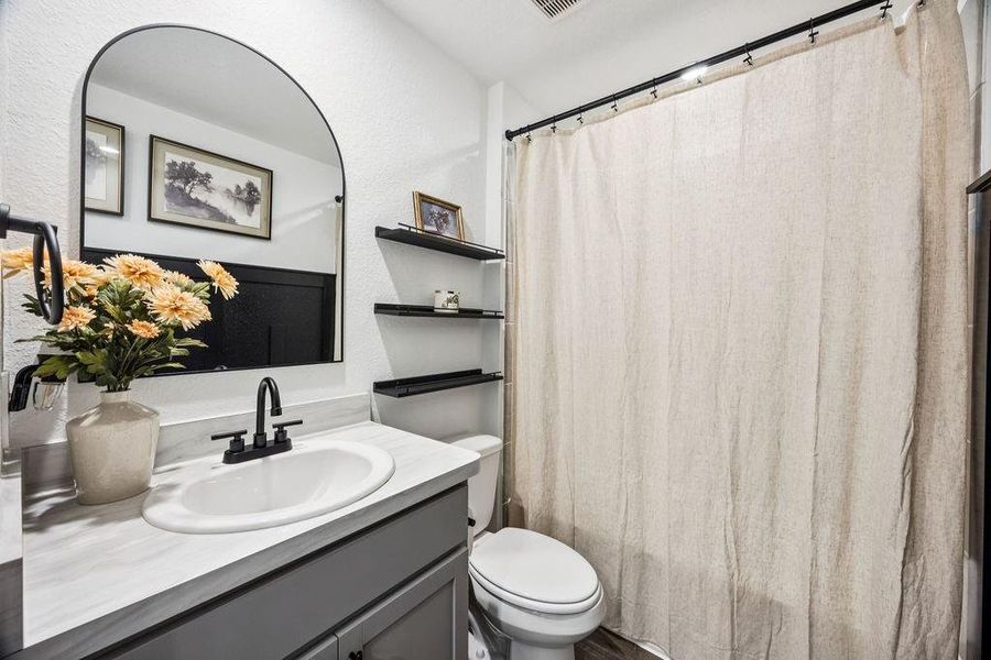Cozy guest bathroom featuring a modern vanity, elegant fixtures, and ample storage. Cozy guest bathroom featuring a modern vanity, elegant fixtures, and ample storage.