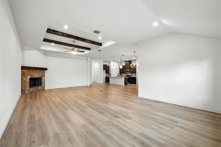 Unfurnished living room featuring a ceiling fan, light wood-style flooring, a fireplace, and recessed lighting