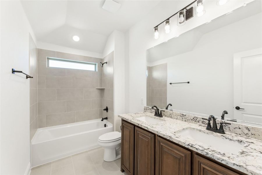 Bathroom with double sink vanity, granite countertop, tiled tub-shower combo, and toilet Bathroom with double sink vanity, granite countertop, tiled tub-shower combo, and toilet
