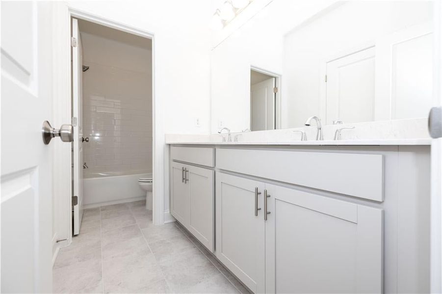 Secondary bathroom - separate shower and restroom with door then dual sinks  - Pictures represent a previously built home, not the actual home.