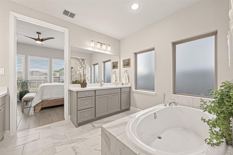 Unwind in this spa-inspired primary bathroom, complete with a deep soaking tub and serene, high-end touches that make it the perfect spot to relax. (Note: Photo is staged; property is currently vacant.) Unwind in this spa-inspired primary bathroom, complete with a deep soaking tub and serene, high-end touches that make it the perfect spot to relax. (Note: Photo is staged; property is currently vacant.)