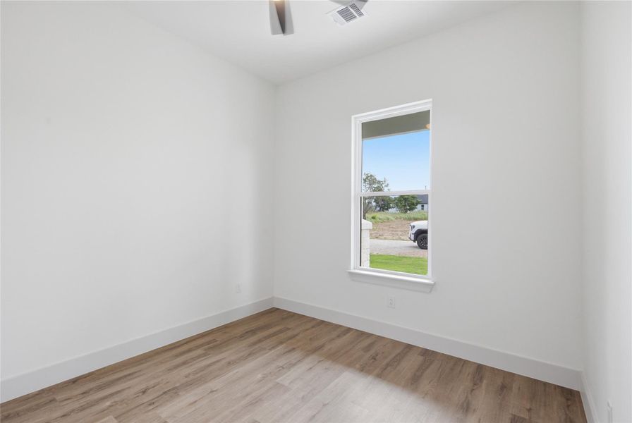 Sun-filled room featuring durable wood flooring and ample natural light. Sun-filled room featuring durable wood flooring and ample natural light.