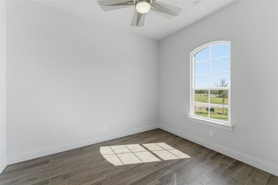 Empty room with dark wood-style floors and ceiling fan