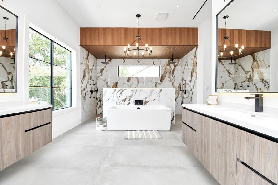 Primary bathroom with separate vanities, standalone tub, and double shower with steam functions. Primary bathroom with separate vanities, standalone tub, and double shower with steam functions.