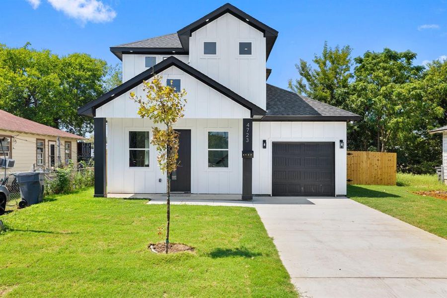 Modern farmhouse style home with board and batten siding, a garage, roof with shingles, and driveway