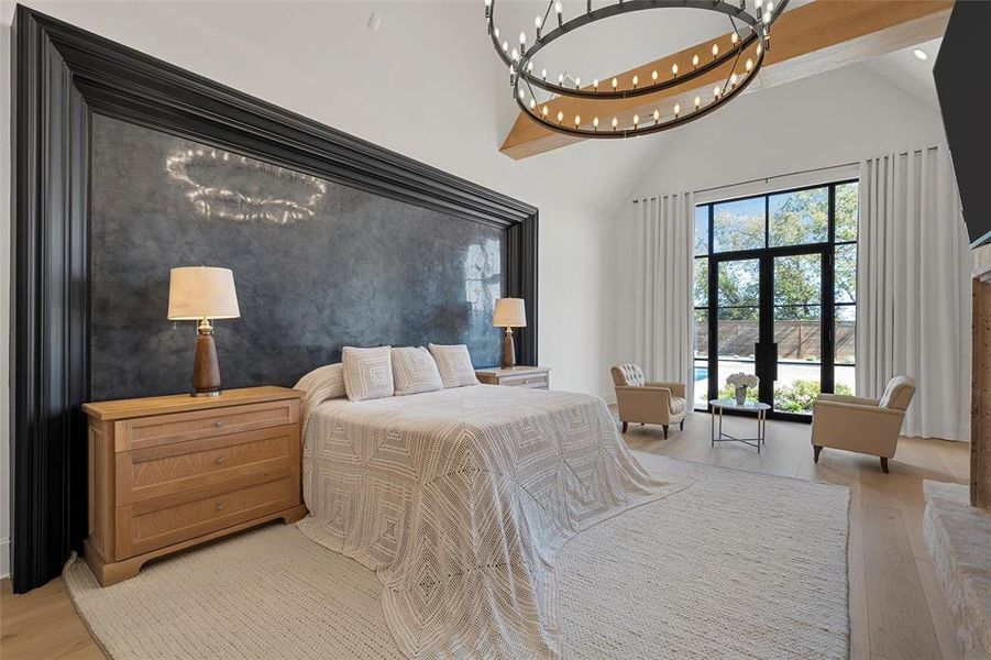 Bedroom with light wood-style flooring, high vaulted ceiling, and a chandelier