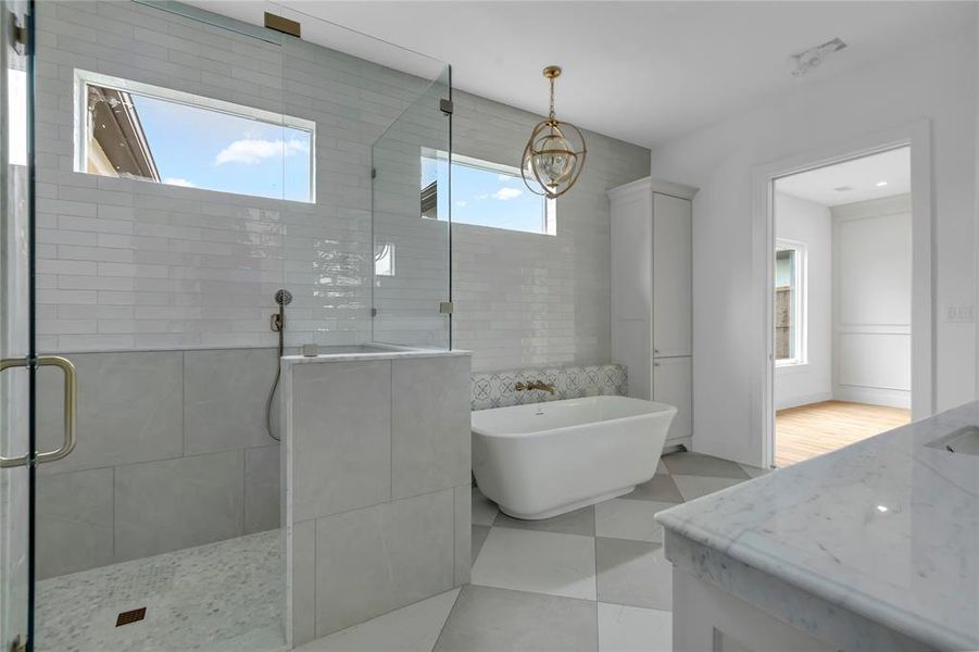 Bathroom featuring vanity, a stall shower, a soaking tub, and light tile patterned floors