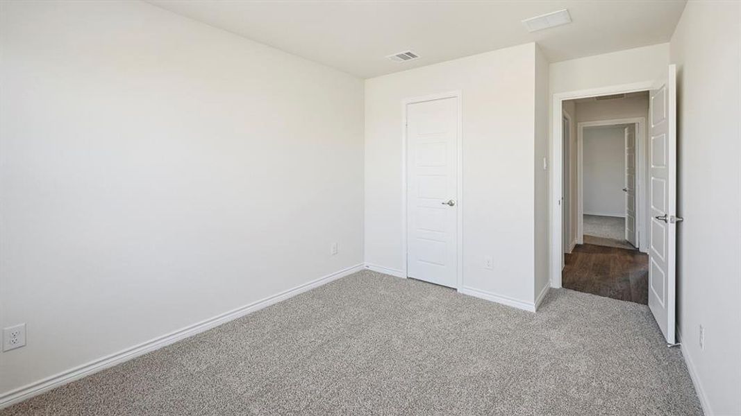 Unfurnished bedroom with light colored carpet and baseboards Unfurnished bedroom with light colored carpet and baseboards