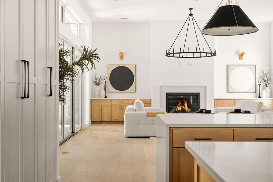 Living area with a glass covered fireplace and light wood-style floors Living area with a glass covered fireplace and light wood-style floors