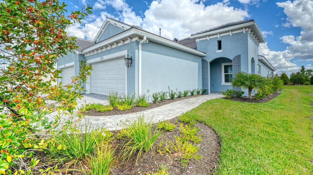 Front exterior of a new home in Palm Grove, Lakewood Ranch, FL, highlighting curb appeal (Image 2). Front exterior of a new home in Palm Grove, Lakewood Ranch, FL, highlighting curb appeal (Image 2).