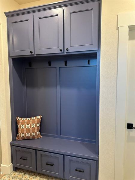 Built-in mudroom station featuring three upper cabinets, three storage drawers, and a bench seat