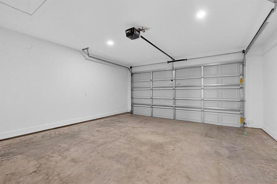 Garage with baseboards and a garage door opener