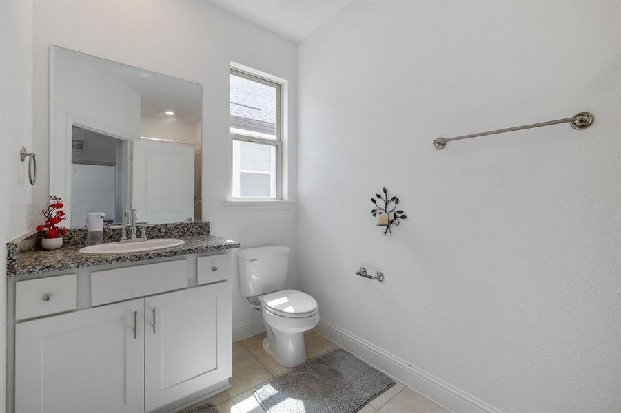 Bathroom featuring vanity, tile patterned flooring, toilet, and baseboards