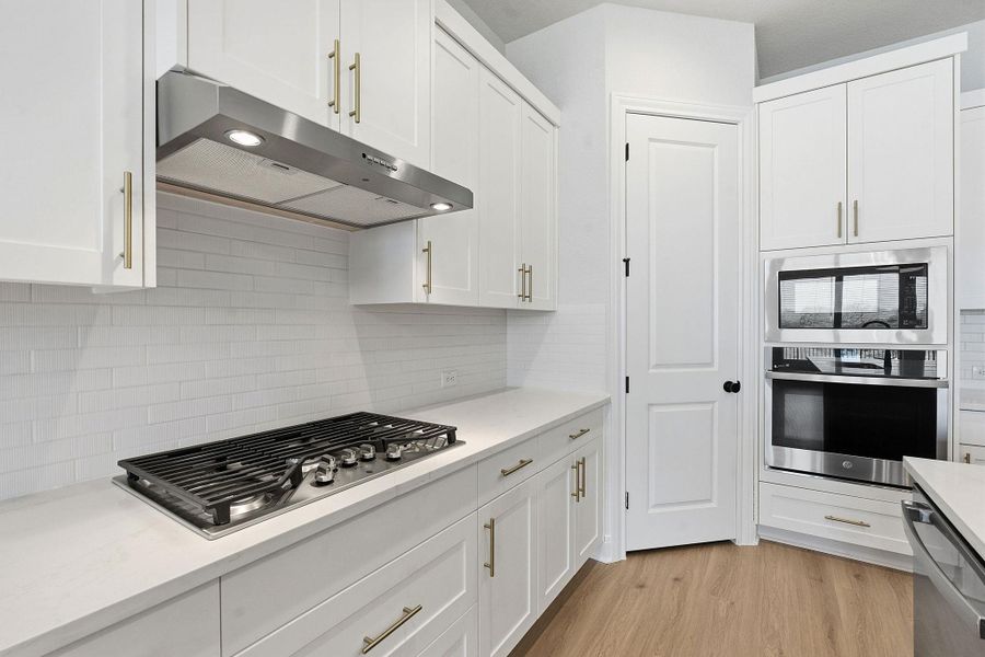 Kitchen featuring white cabinetry and stainless steel appliances