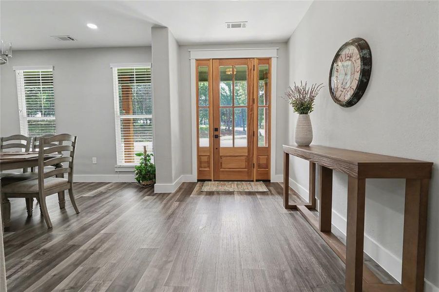 Entryway featuring a wood-panel door with glass inserts, wood-finish flooring, and recessed lighting