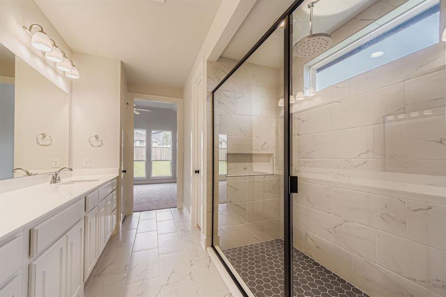 Full bathroom with plenty of natural light, a marble finish shower, and vanity
