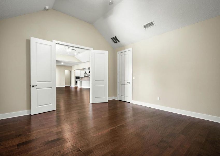 Media room with wood floors and double doors.