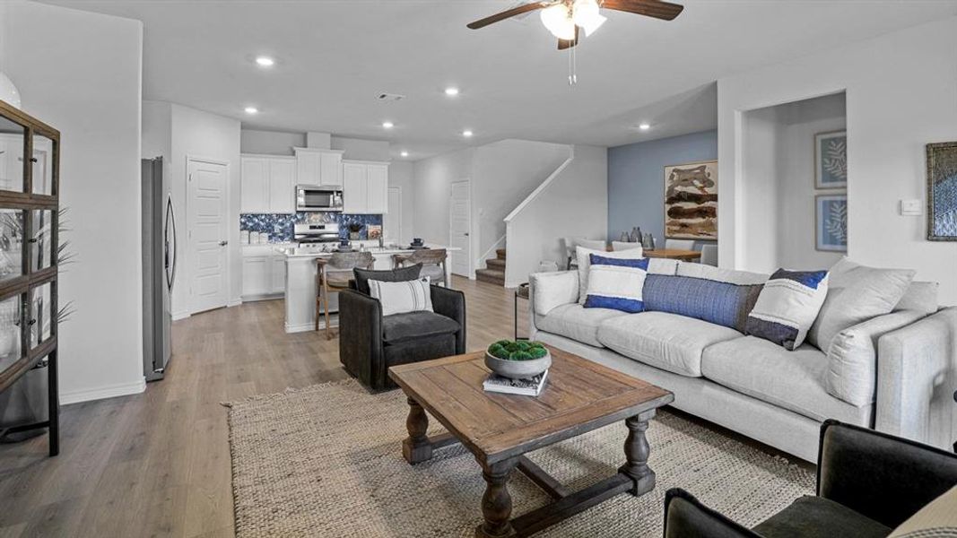 Living room with a ceiling fan, light wood finished floors, and recessed lighting