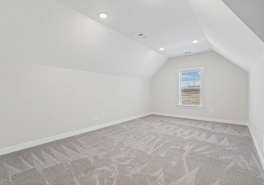 Vaulted ceiling with recessed lighting, single window with blinds, and light-toned carpeting