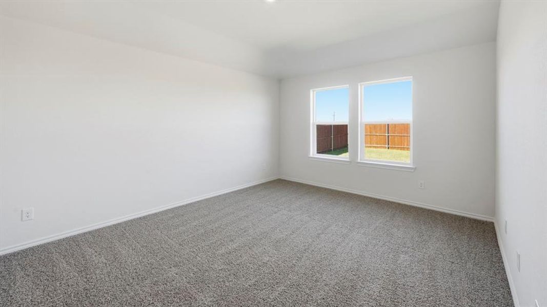 Carpeted spare room featuring baseboards