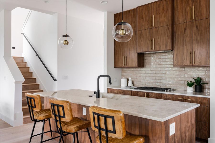 Ample prep space surrounds the kitchen, complemented by a stylish tile backsplash that adds texture and sophistication to this modern culinary hub.